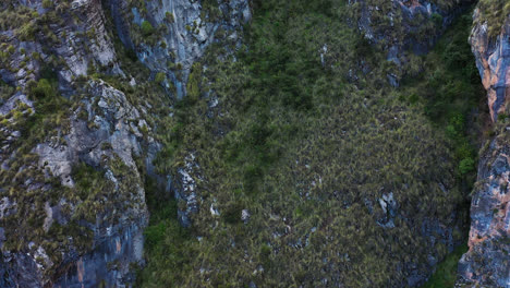 hermosa fotografía de un drone de una montaña con roca y vegetación alrededor del lago millpu en ayacucho, perú en un día nublado
