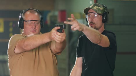 a man learns how to shoot a gun at the shooting range