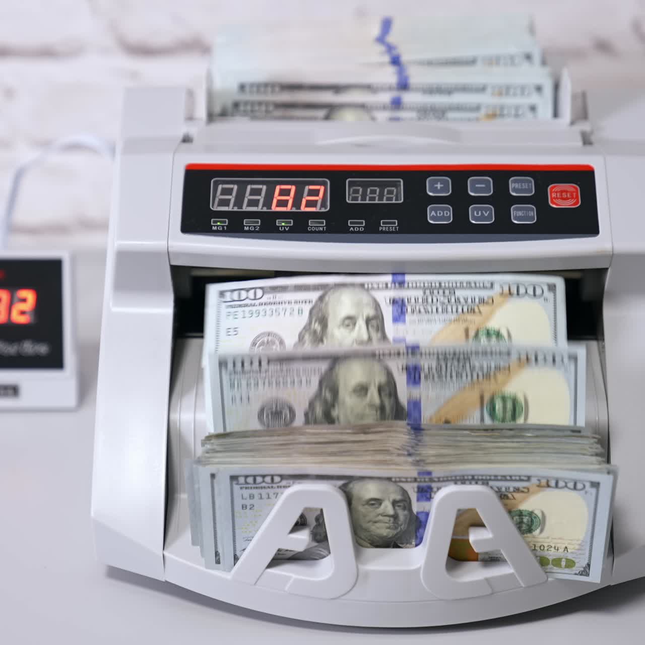 Operazioni di conteggio in banca. Meccanismo automatico che conta banconote da cento dollari. Macchina contabanconote elettronica in banca.