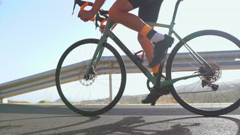 engaging in outdoor exercise, a man cycles on a deserted morning road with his road bike. the slow-motion recording underlines the excitement of extreme sports