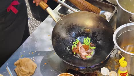 chef cooking stir-fry in wok