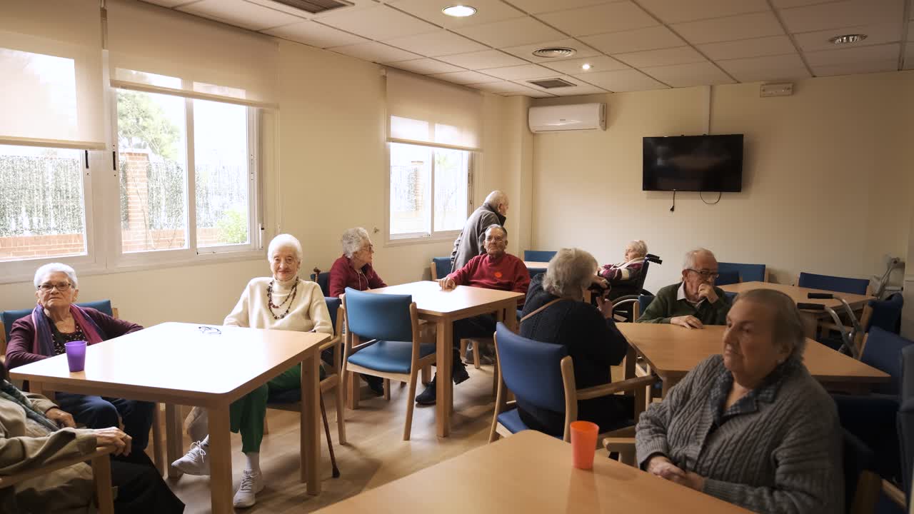 Elderly men and women sitting in nursing home canteen