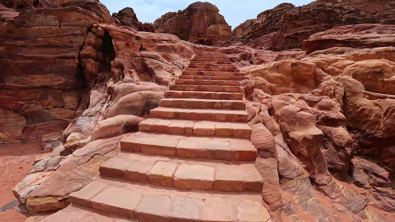 Stairs to the rocks polished by the power of wind. Low angle view at the sandstones of Petra, Jordan, West Asia.