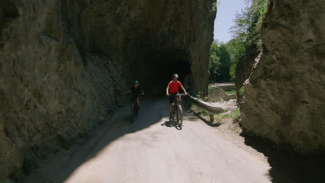 father and son mountain biking through a tunnel