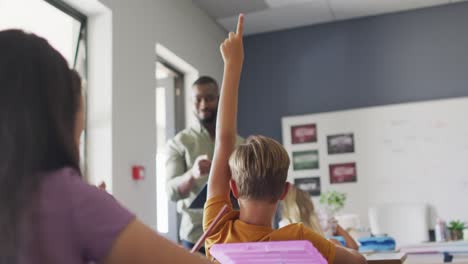 video of happy african american male teacher during lesson with class of diverse pupils