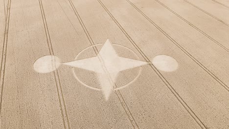 Unexplained-crop-circle-design-in-middle-of-dry-countryside-farmland,-aerial