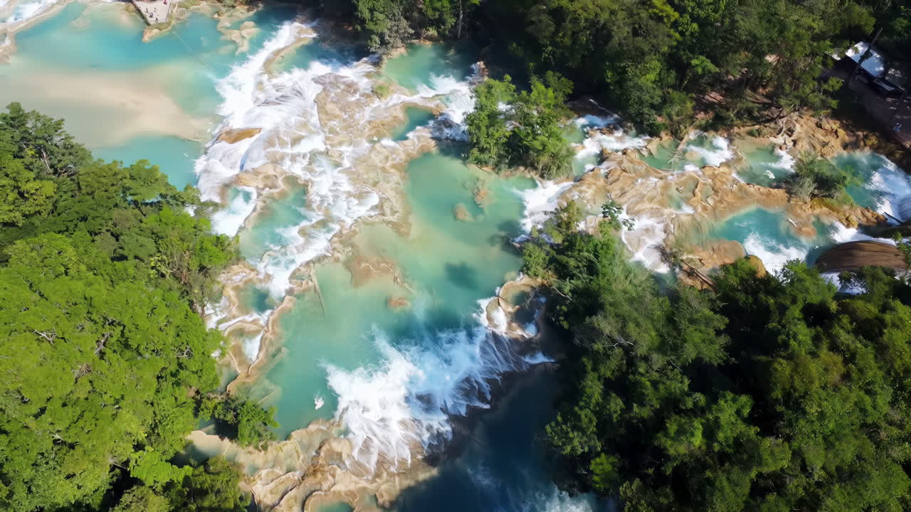 Vista aerea con drone di molteplici cascate turchesi e piscine naturali circondate da una fitta foresta tropicale ad Agua Azul nel Messico meridionale.