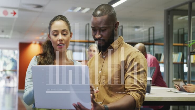 Animation of statistical data processing over diverse man and woman discussing over laptop at office