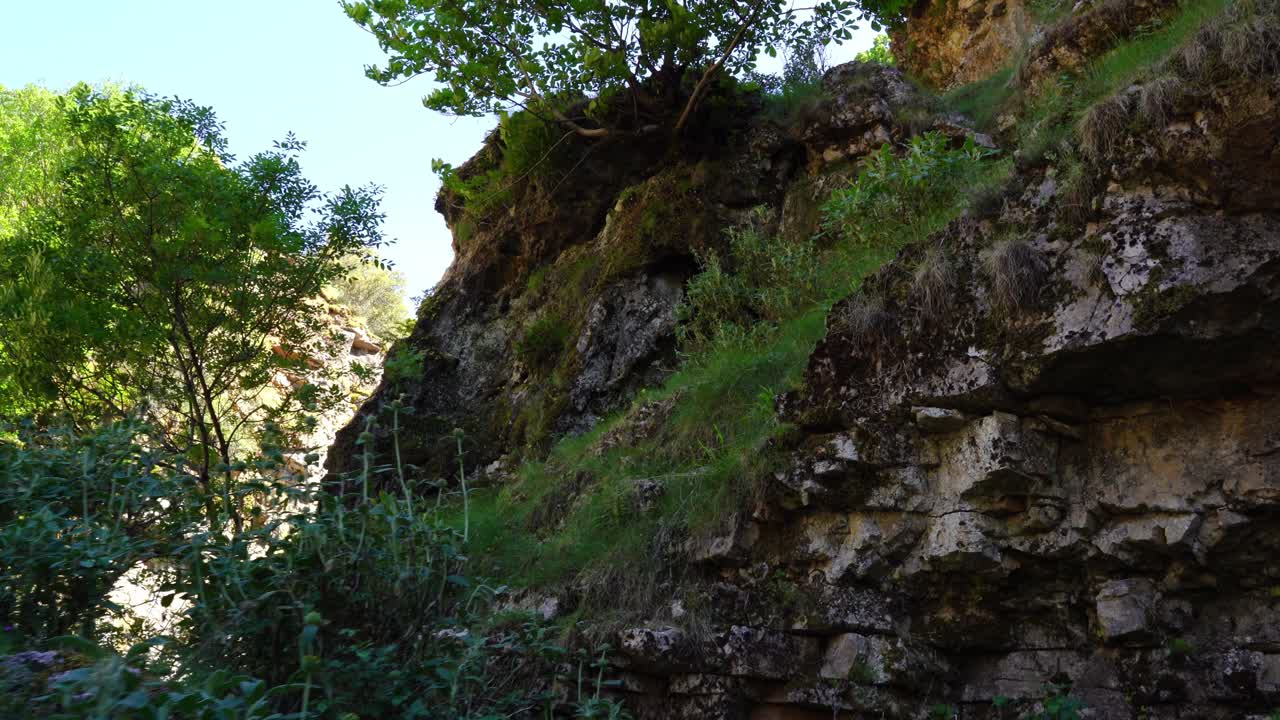 senderismo en la ladera de la montaña con rocas y vegetación verde, escalada al aire libre en albania