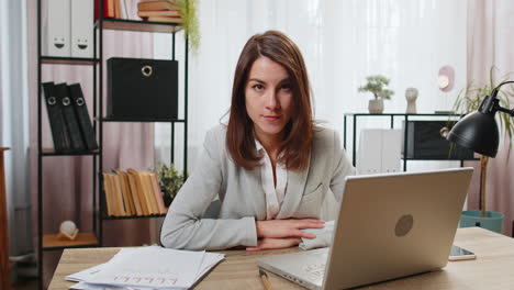 Business-woman-working-on-laptop-computer-shakes-finger-and-saying-no-be-careful-disapproval-sign