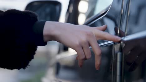 woman touches car with fingers