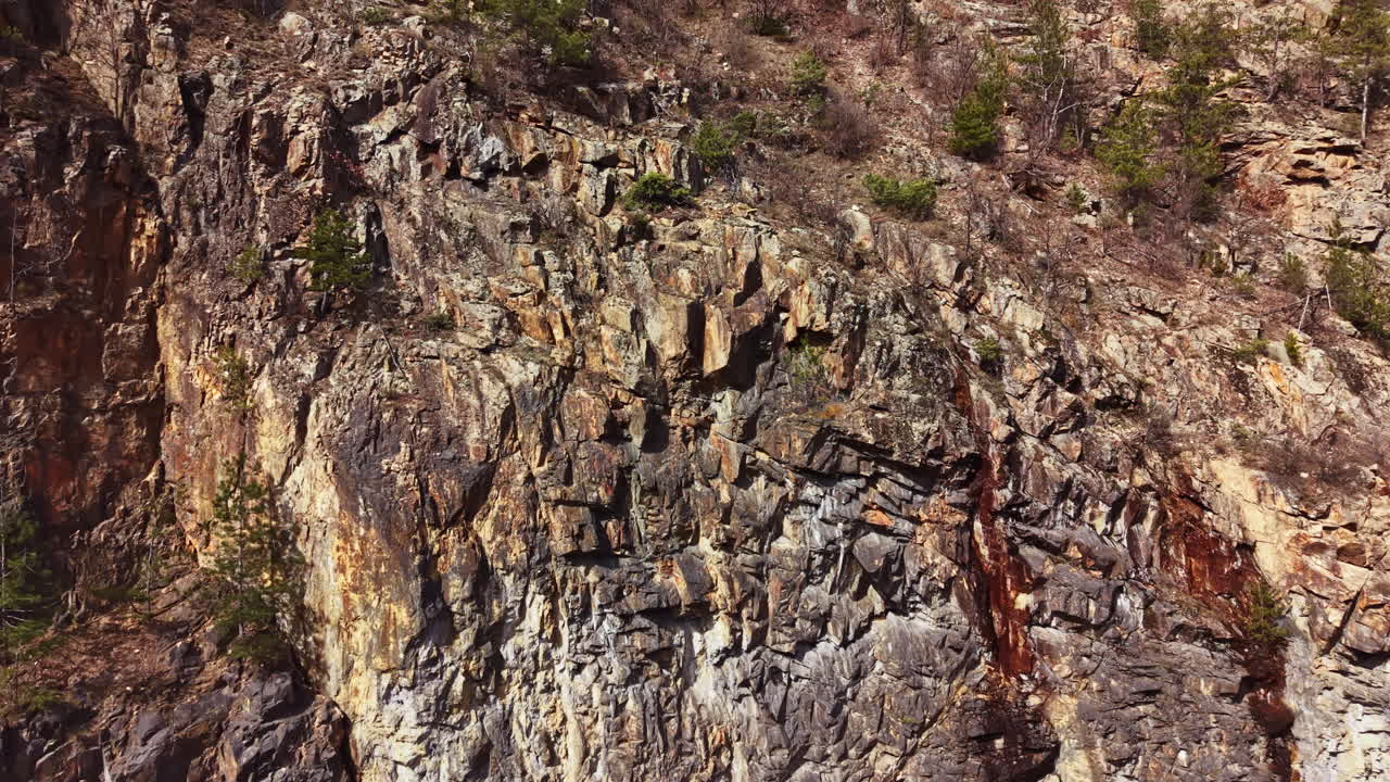 Paesaggio roccioso caratterizzato da scogliere ripide e vegetazione rada in una giornata di sole in una zona remota