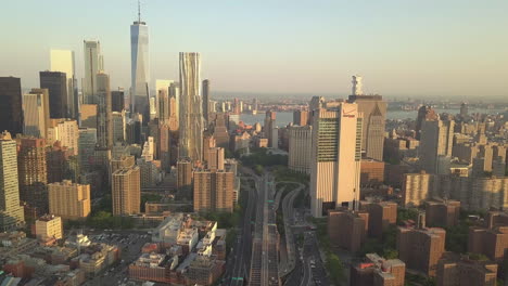 AERIAL:-Overhead-Birds-Eye-View-of-Brooklyn-Bridge-with-Tilt-up-to-Reveal-Manhattan-New-York-City-Skyline-at-Sunset-in-beautiful