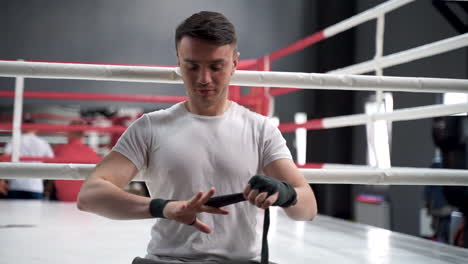 Strong-Athlete-Man-Wrap-His-Hands-With-Boxing-Bandages-Before-Training