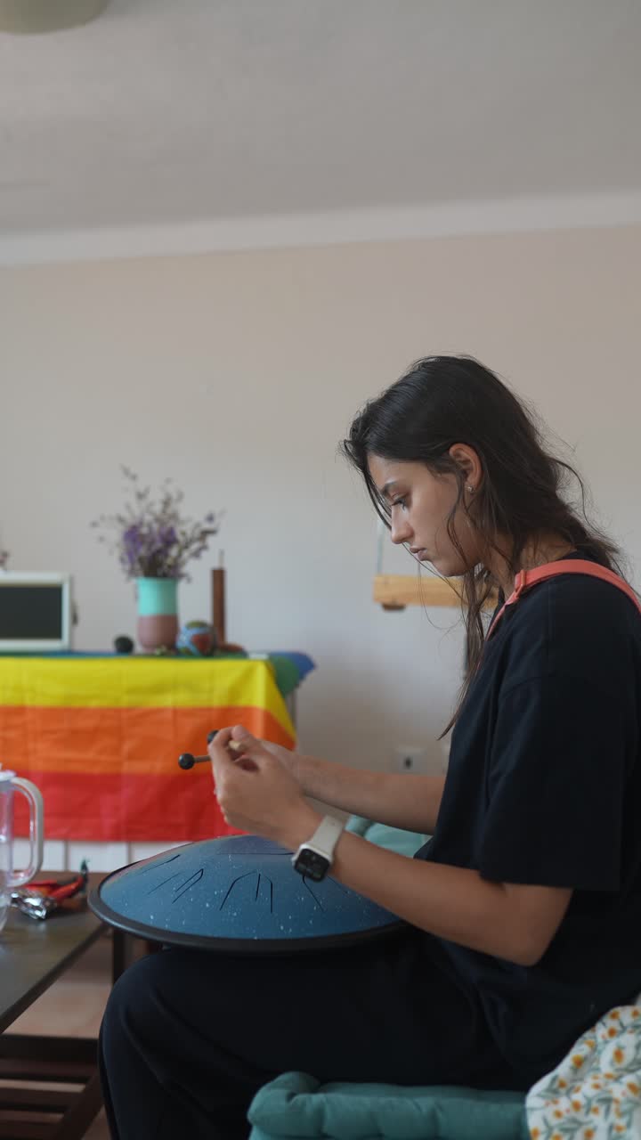 Young Woman Playing a Singing Bowl at Home
