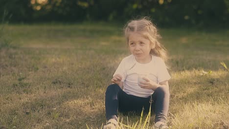 young-funny-blond-lady-sits-in-green-tree-shadow-on-meadow