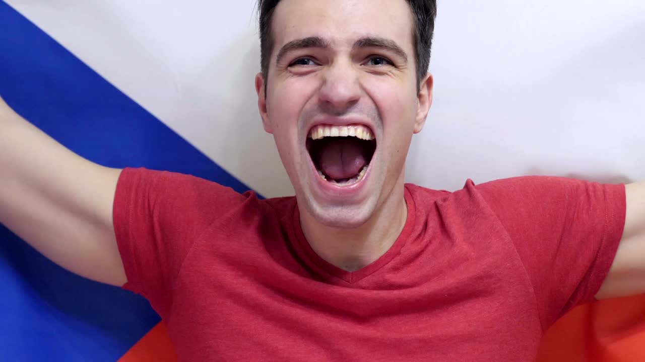 un joven checo celebra sosteniendo la bandera de la república checa en cámara lenta