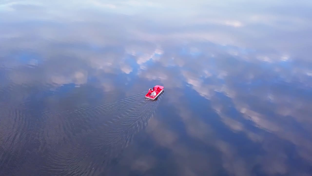 familia en un bote de pedales al atardecer toma aérea