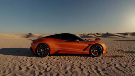 orange sports car in the desert at sunset