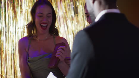 video of diverse doorman greeting happy female friends walking into nightclub arm in arm laughing