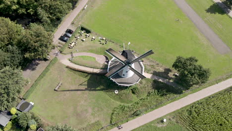 aerial of windmill with rotating blades in rural area