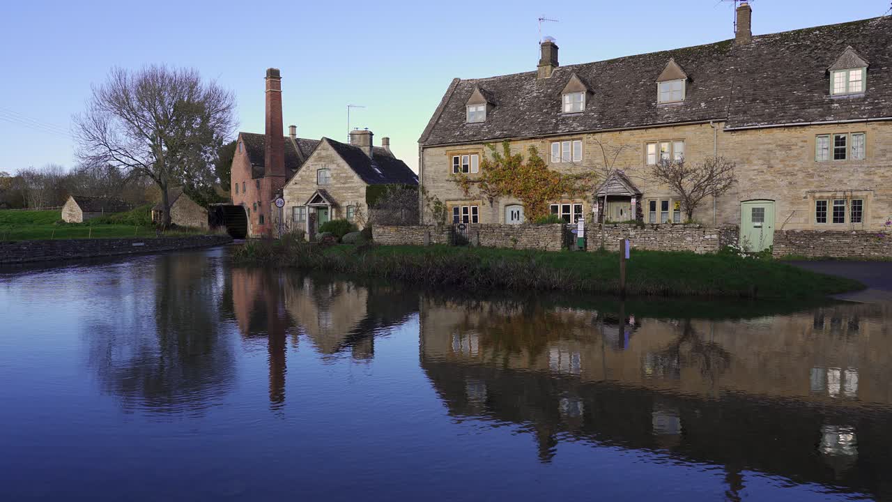 encantador pueblo de cotswolds de lower slaugher con sus casas históricas y su molino de agua reflejándose en el ojo del río