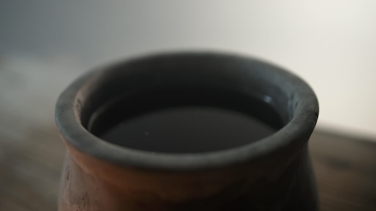 Closeup of wine in a clay jar in glowing, ambient light, for the last supper, communion, Christian sacraments, representing the blood of Jesus shed on the cross.