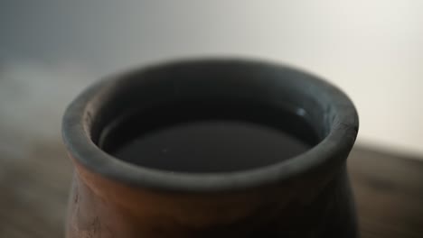 closeup of wine in a clay jar in glowing, ambient light, for the last supper, communion, christian sacraments, representing the blood of jesus shed on the cross.