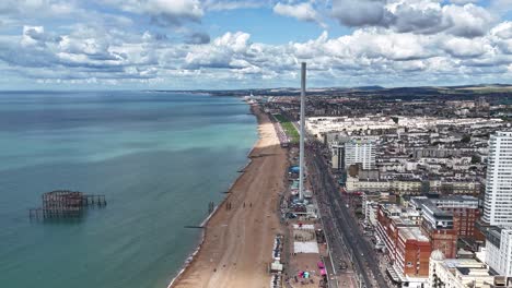 timelapse aerial of brighton pride 2025 along the seafront, with clouds forming overhead and colourful crowds moving below, appearing like tiny ants in a vibrant coastal celebration