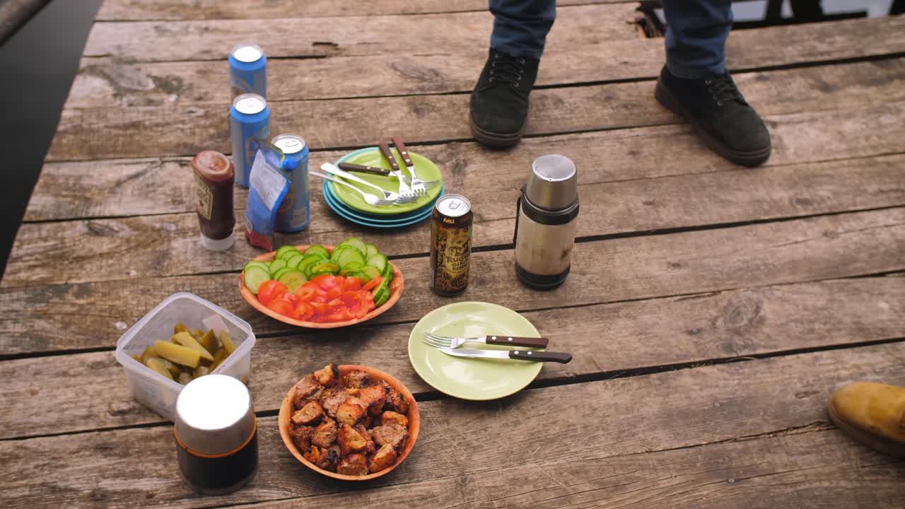 Picnic lunch on the wooden bridge near lake.