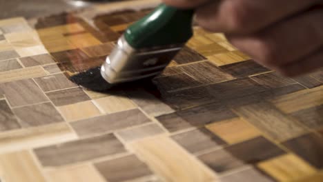 primer plano de un pincel poniendo aceite de madera en una madera