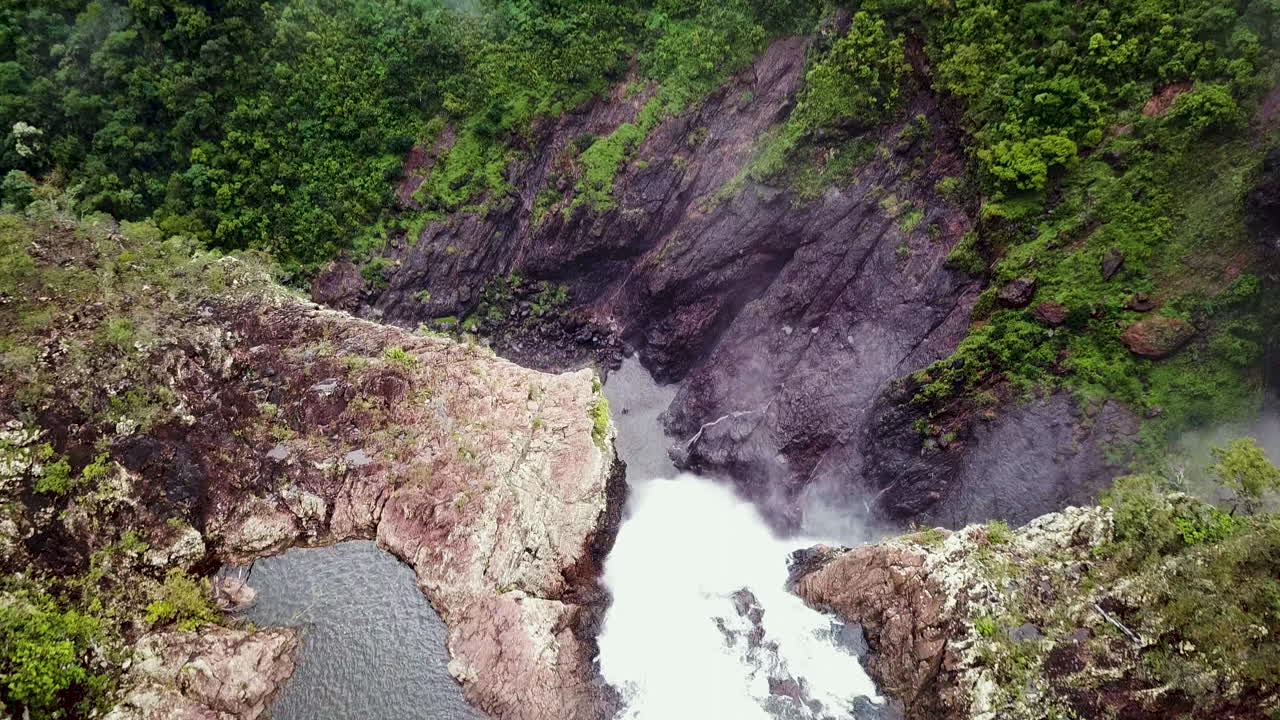 drone volando directamente sobre una enorme cascada que revela una enorme caída al fondo
