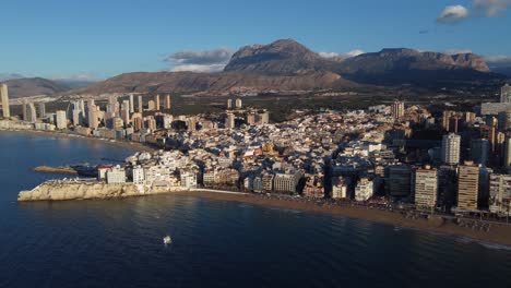 benidorm, spain with puig campana mountain in the background - aerial establishing shot