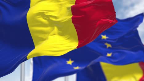 detail of the national flag of romania waving in the wind with blurred european union flag