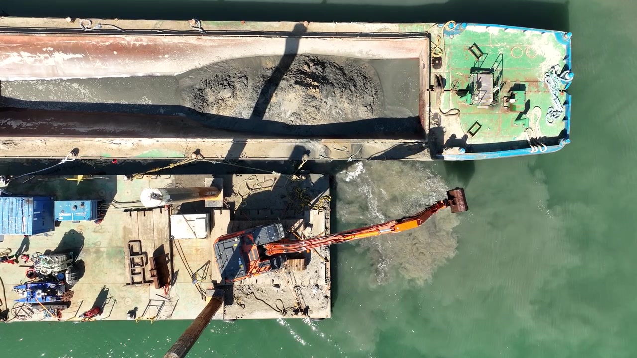 Dragaggio della sabbia ed escavatore al lavoro su chiatta e piattaforma di lavoro nel porto - vista drone