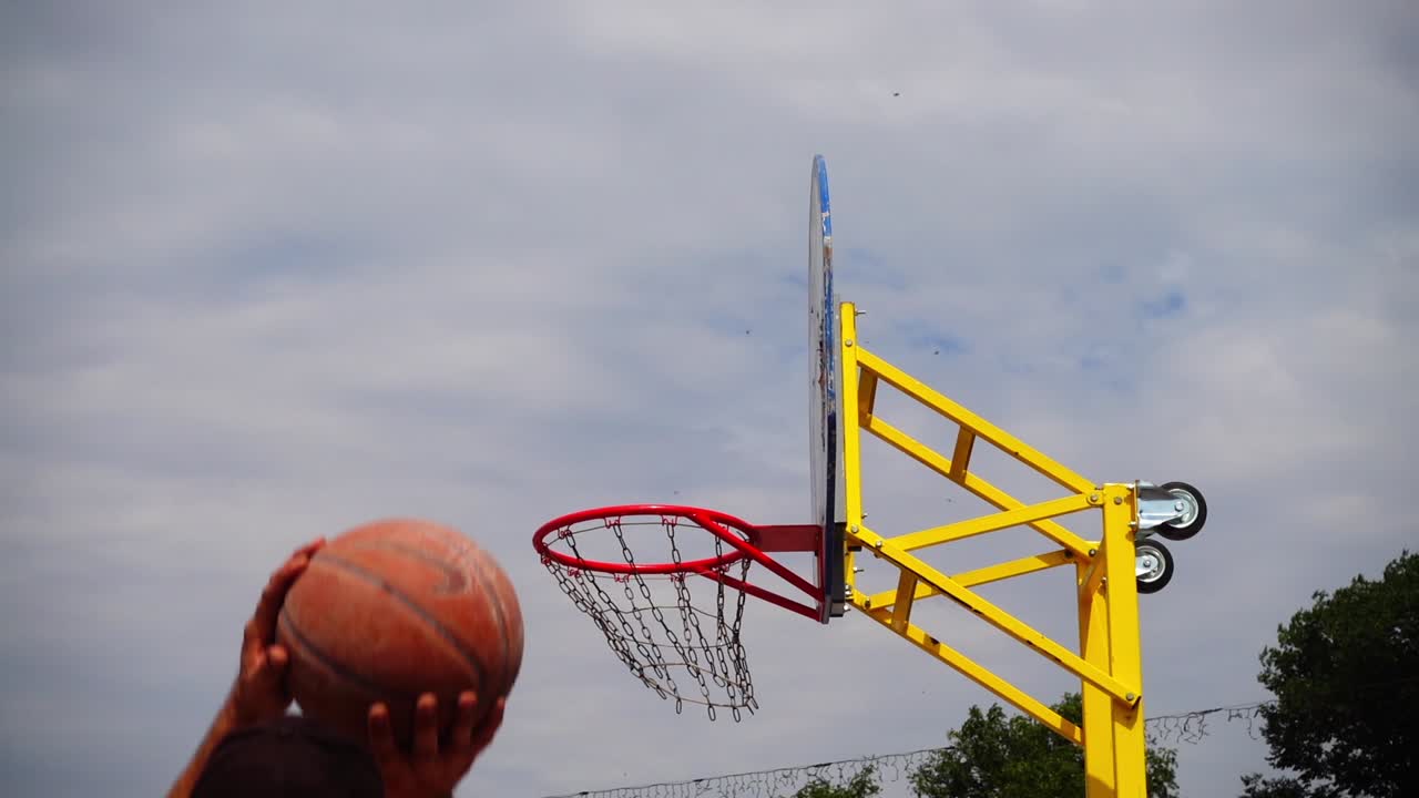 Pallacanestro da strada. La palla vola verso il canestro. Al rallentatore