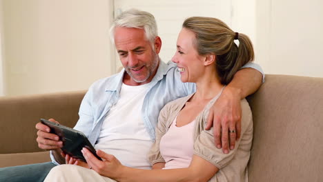 Pareja-Feliz-Usando-Tableta-Juntos-En-El-Sofá