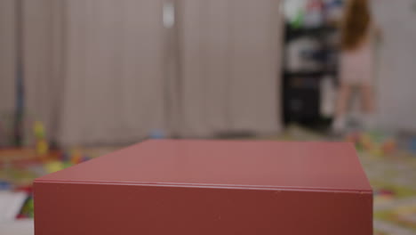 close up view of hands of two children playing with a wooden car and wooden cube in classroom in a montessori school