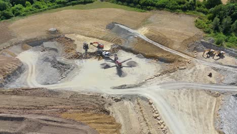 sweeping aerial video of open mine excavation, machinery, and sediment stockpiles near grantham