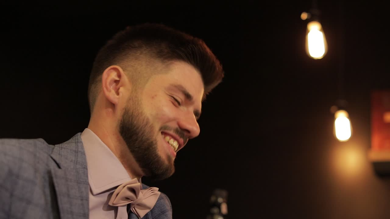 el novio con una barba negra mira a la cámara. hombre de negocios. pajarita rosa