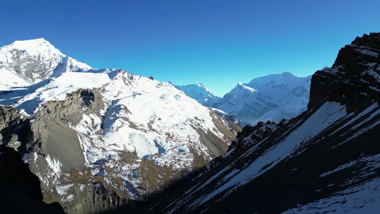 paisaje de montaña de invierno nevado aéreo con valles empinados por debajo en un día soleado