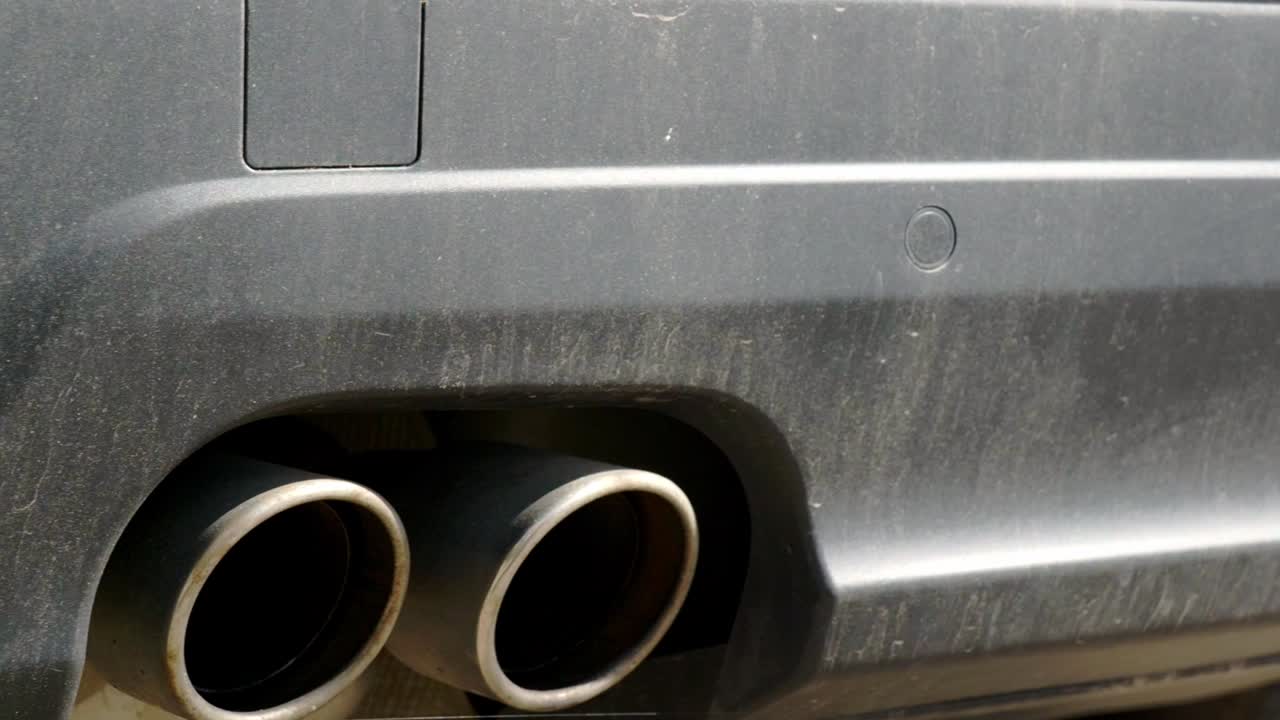 Close up or dirty rear bumper and exhaust with black trim