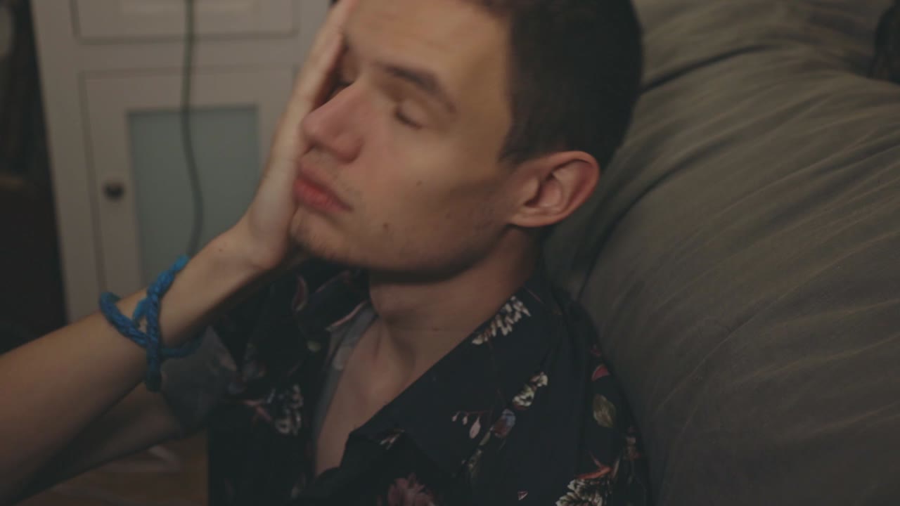 소파에 기대어 있는 동안 깊이 생각하는 화가 난 청년 - 클로즈업 샷