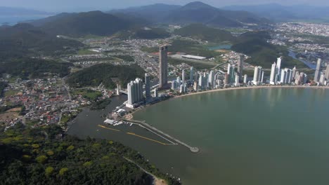 aerial view of beachfront hotels, apartment buildings, beach, camboriu river, sea and balneario camboriu city in brazil