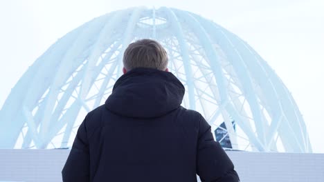 man looking at a dome-shaped building