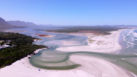 Los-Bañistas-Disfrutan-Del-Agua-Cristalina-Del-Estuario-Del-Río-Klein-Que-Se-Adentra-En-El-Mar,-Vista-Aérea