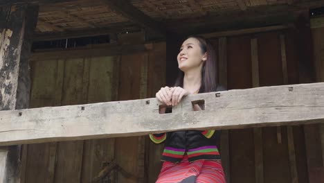 woman in traditional clothing on a wooden balcony