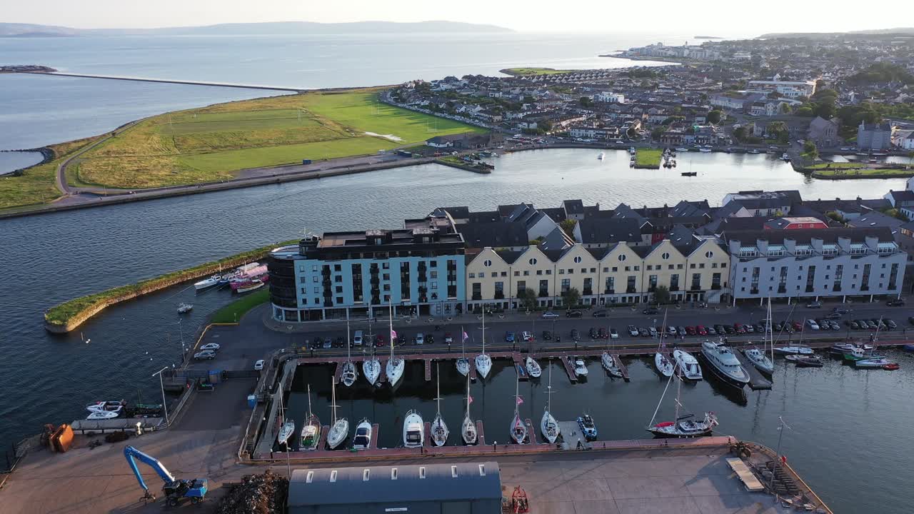 The edge of the Irish city of Galway as it meets the sea. This flyover shot from a drone showcases some of the vast Irish landscapes in the distance as well as the city below