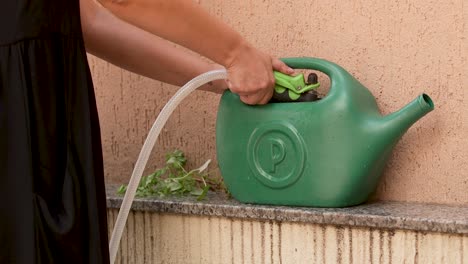 filling a green watering can