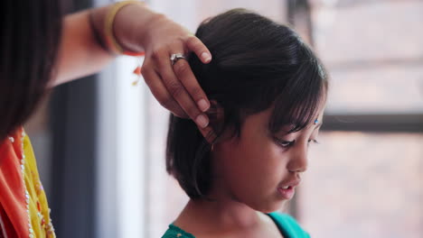 madre peinando el cabello de su hija